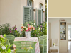 Little Greene - Clay 39 op een gevel met lichtgroene luiken en bloemen