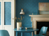 Blauw behang met sierlijke krullen Hoja - Air Force Blue van Little Greene toegepast in een woonkamer met grote schouw