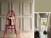 Little Greene - Portland Stone Dark 157 op de wand met platte sierlijsten en een rode stoel
