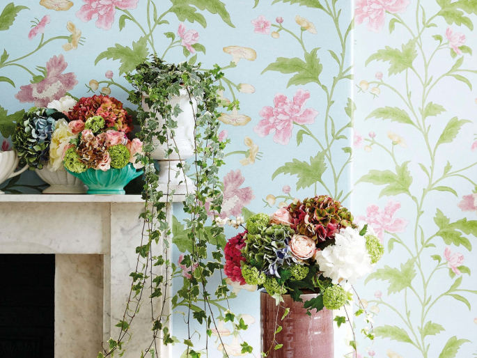 Sfeerfoto China Rose - Blue Lustre behang van Little Greene met blauwe achtergrond en grote roze bloemen